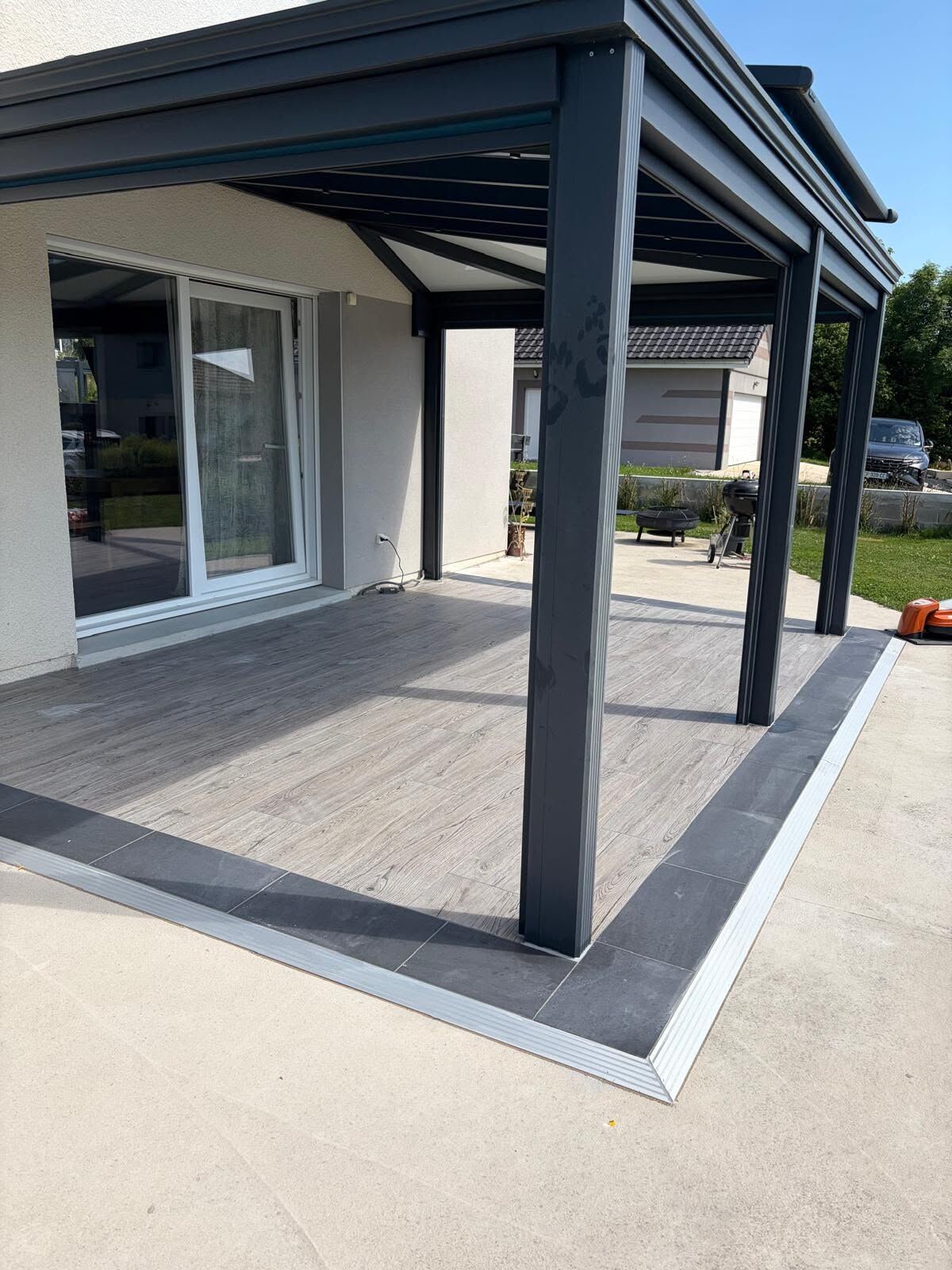 Terrasse en carrelage effet bois sous pergola